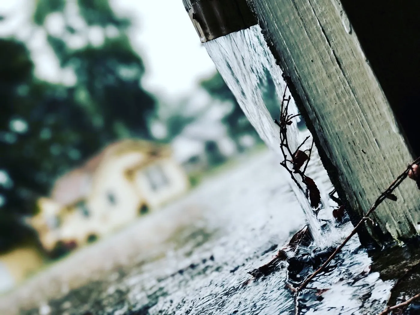 Rainwater flowing from a house gutter downspout during a storm