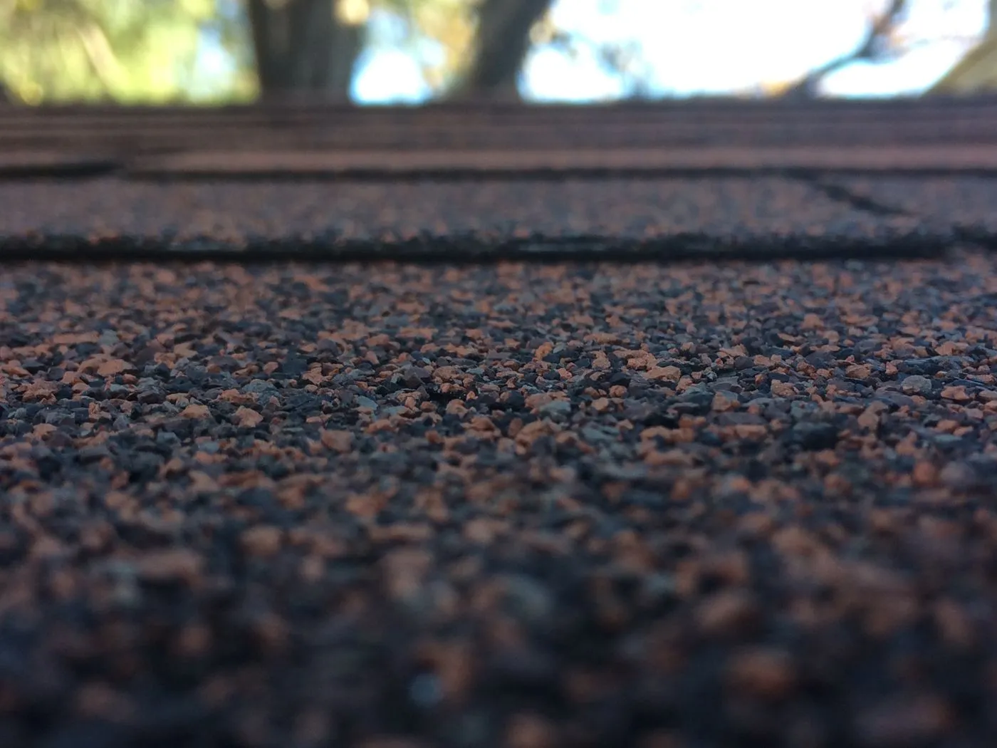 Close up of asphalt shingle roof repair showing damaged course
